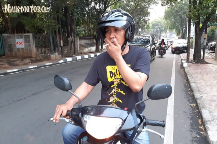 merokok sambil mengendarai motor